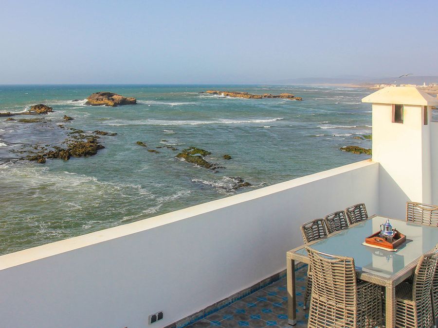 Terrasse avec table face à l'océan et aux rochers