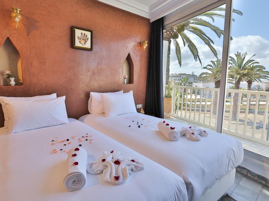 Appartement premium : chambre ouverte sur une terrasse et des palmiers