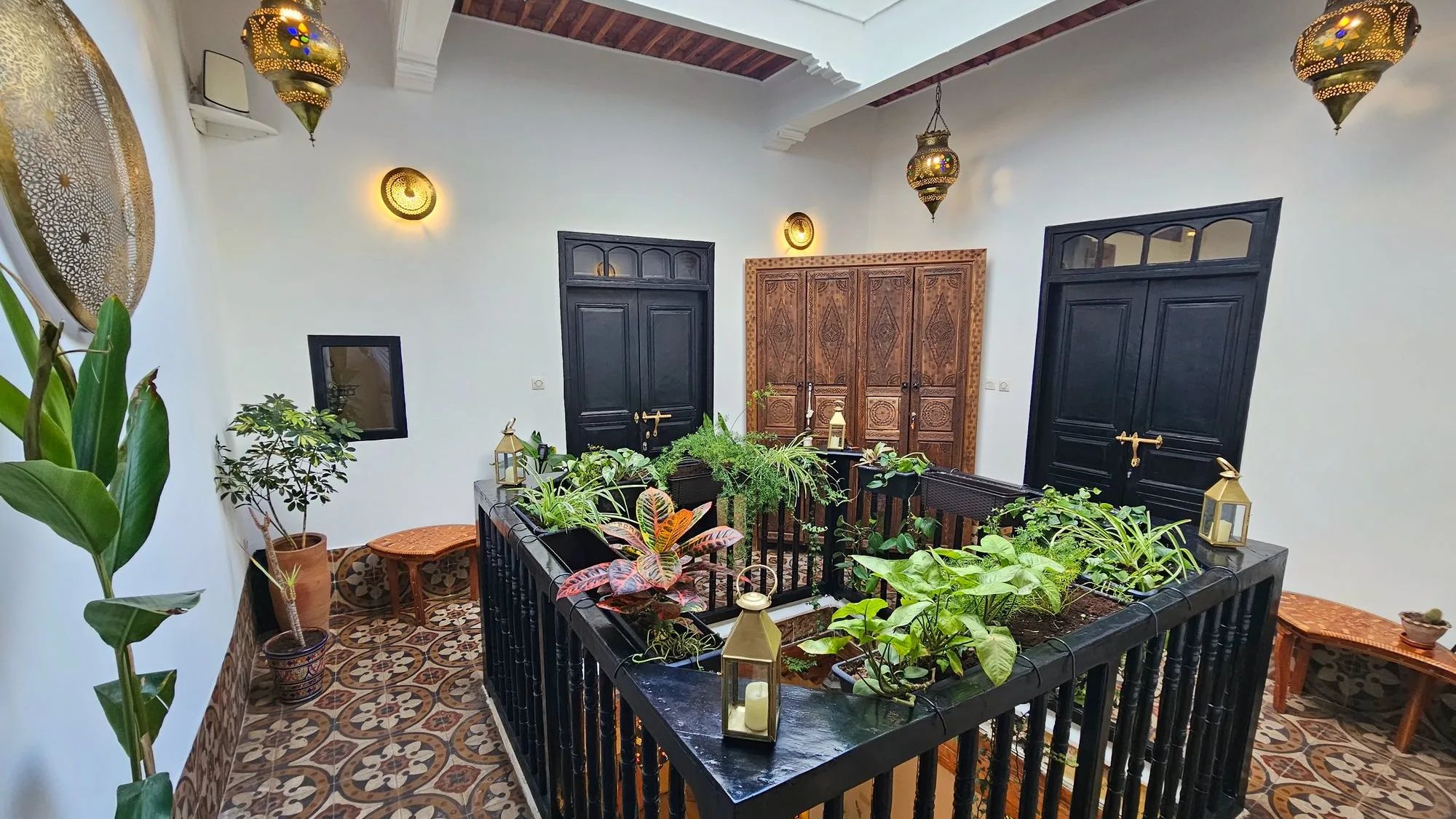Patio d'un riad d'Essaouira, portes noires et plantes